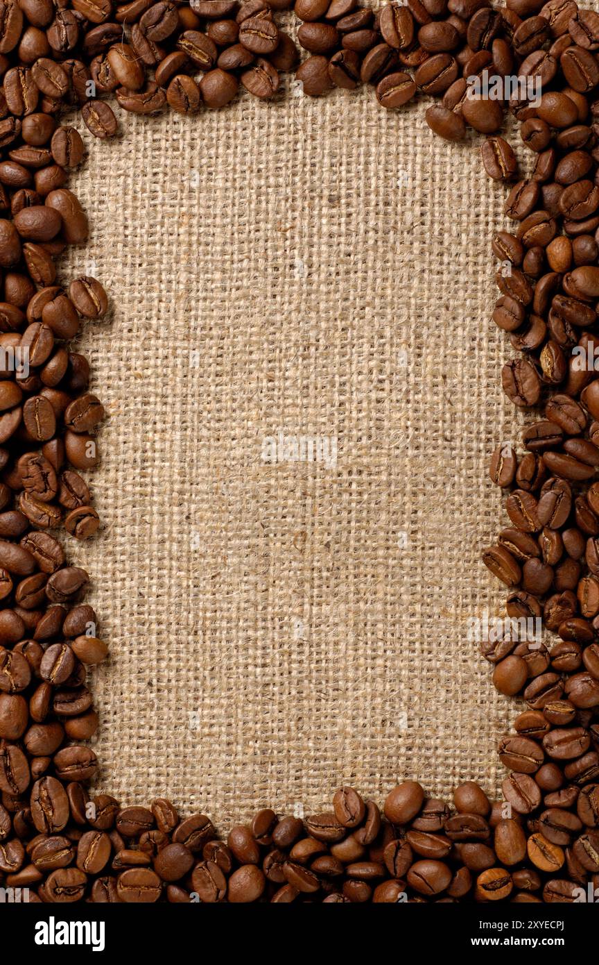 Vertical frame made from aromatic coffee beans on sacking fabric background Stock Photo
