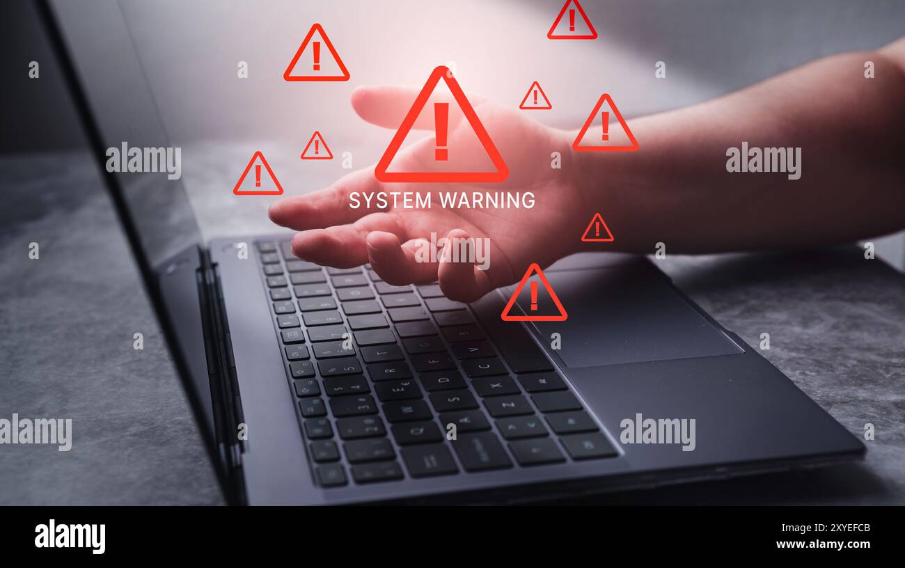 Laptop with hologram warning sign for notification error. Programmer, developer and maintenance system concept. Scam virus attack. Security protection. Stock Photo