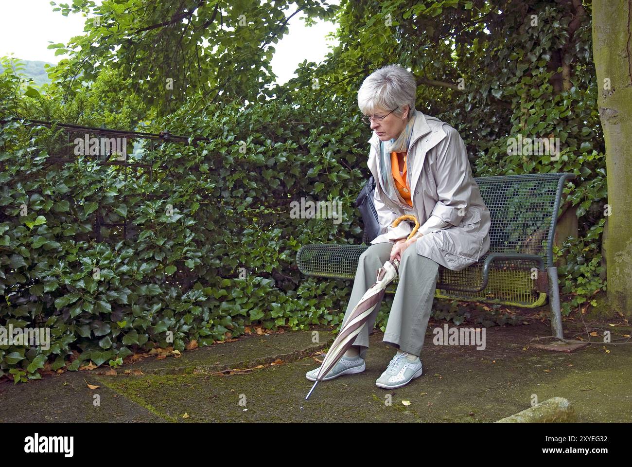 Lonely woman sitting on a park bench Stock Photo - Alamy