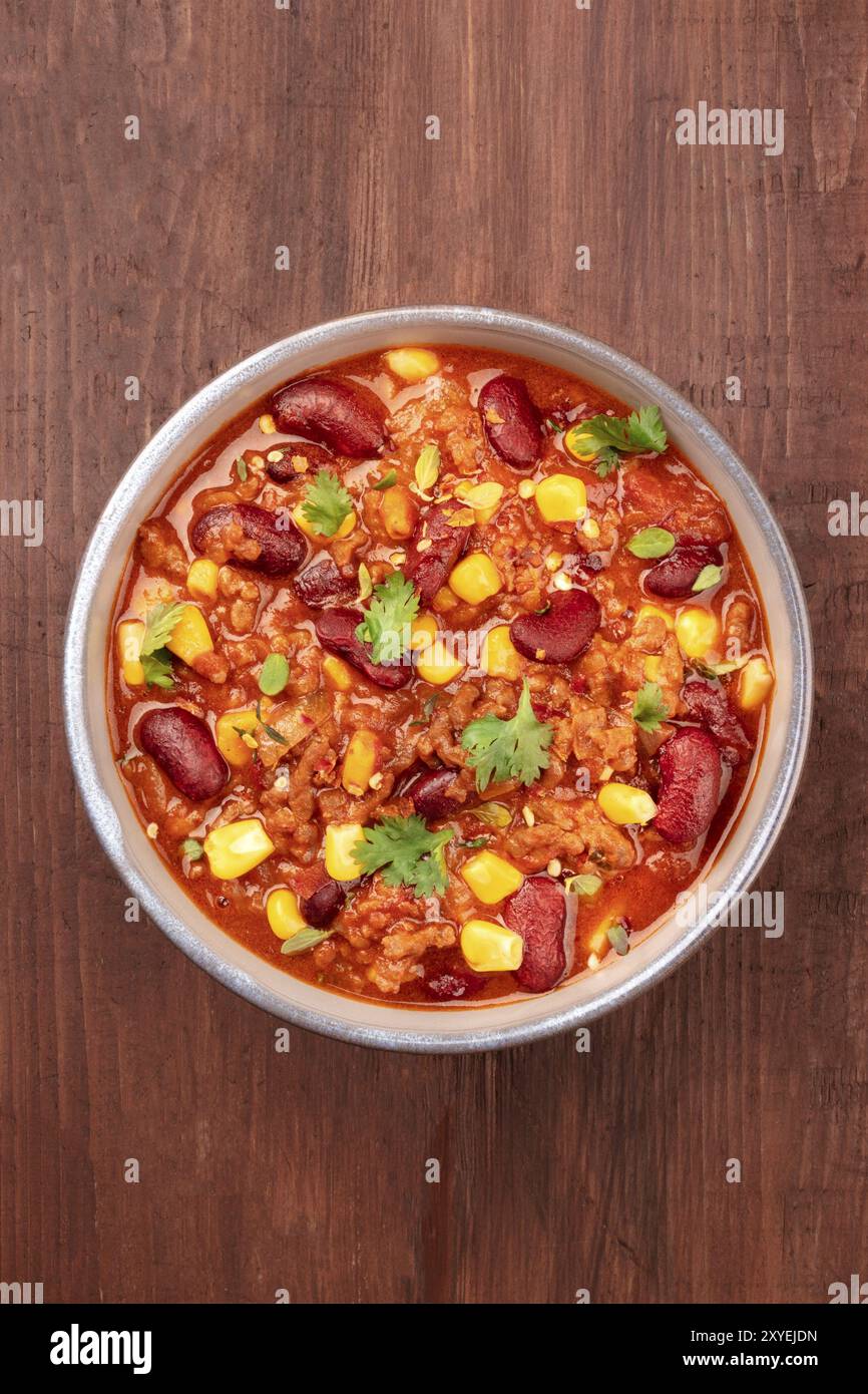 Chili con carne, traditional Mexican dish, shot from the top on a dark rustic wooden background with a place for text Stock Photo