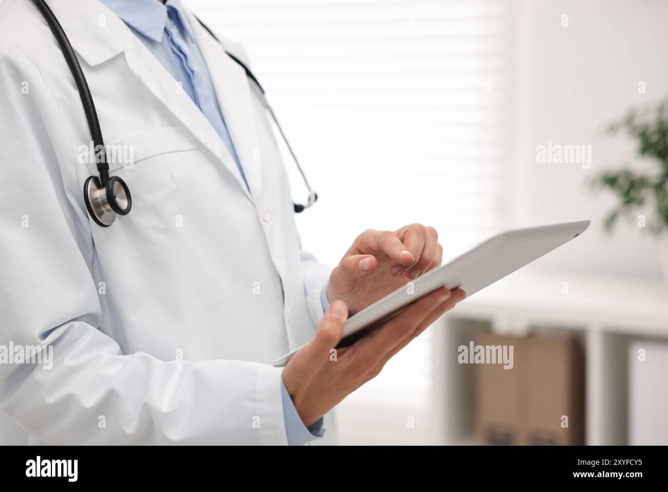 Doctor using tablet in hospital, closeup view Stock Photo