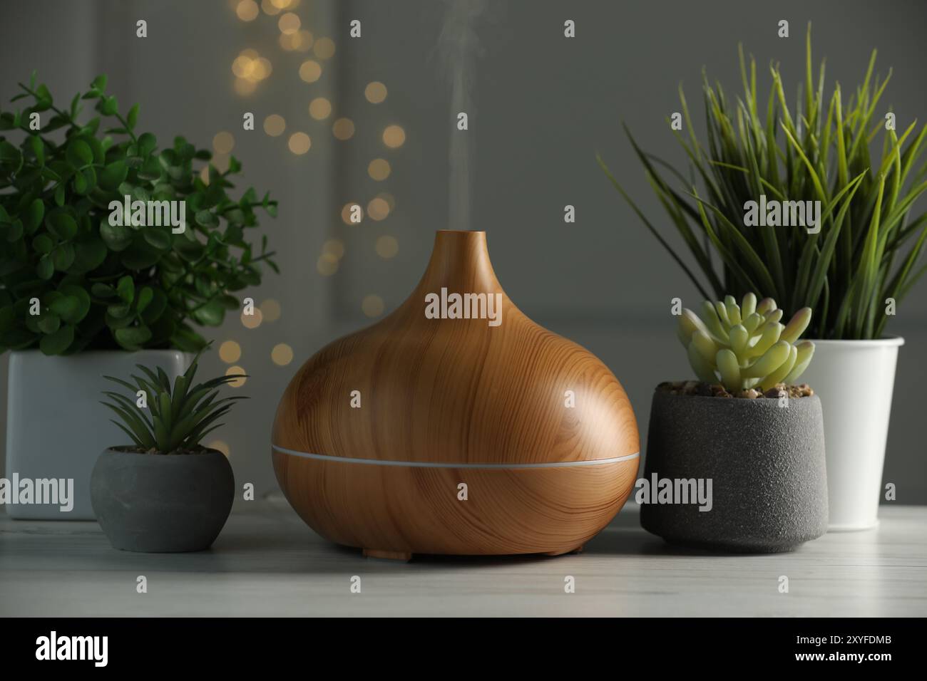Aroma oil diffuser and houseplants on white wooden table Stock Photo ...