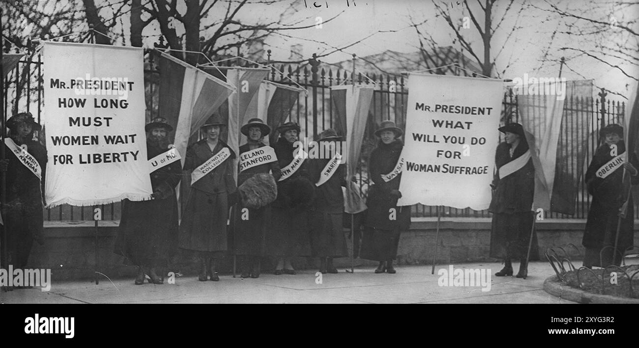 The Silent Sentinels, women suffragists picketing in front of the White House c. February 1917. Banner on the left reads, "Mr President, How long must women wait for Liberty?", and the banner to the right, "Mr President, What will you do for women's suffrage?"[304]… Stock Photo