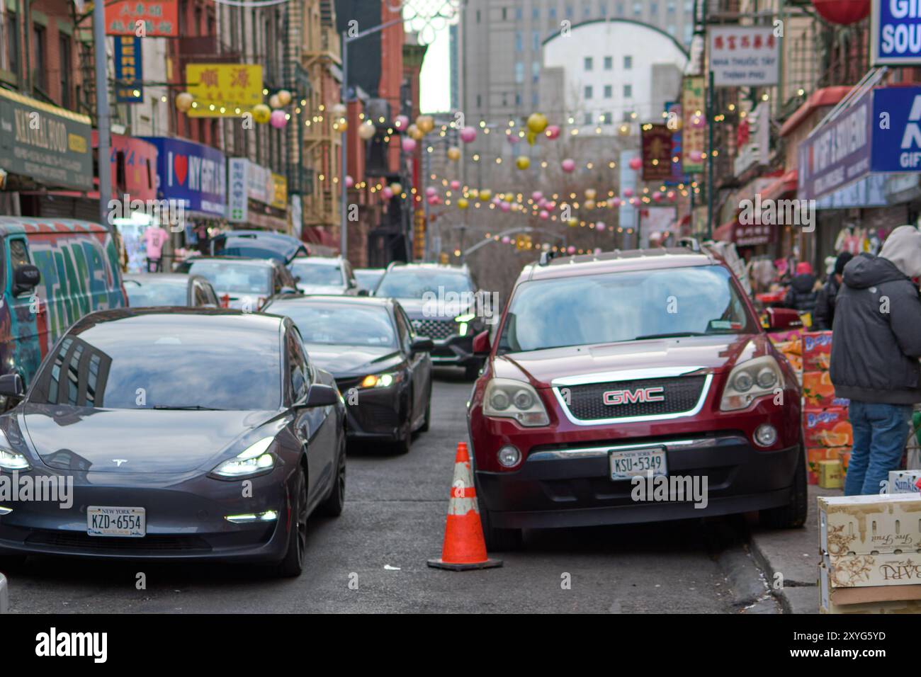 New York, United States - August 29, 2024: Dynamic view of a busy street with cars and pedestrians in New York famous Chinese neighborhood. Stock Photo