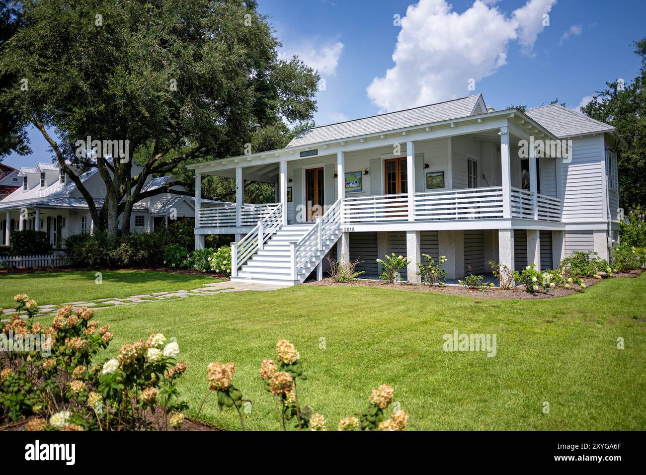 SULLIVAN'S ISLAND, South Carolina, United States — A charming white wooden house on Middle Street, exemplifying the traditional coastal architecture of Sullivan's Island. This well-preserved home showcases the island's historic character and laid-back beach town atmosphere. Stock Photo