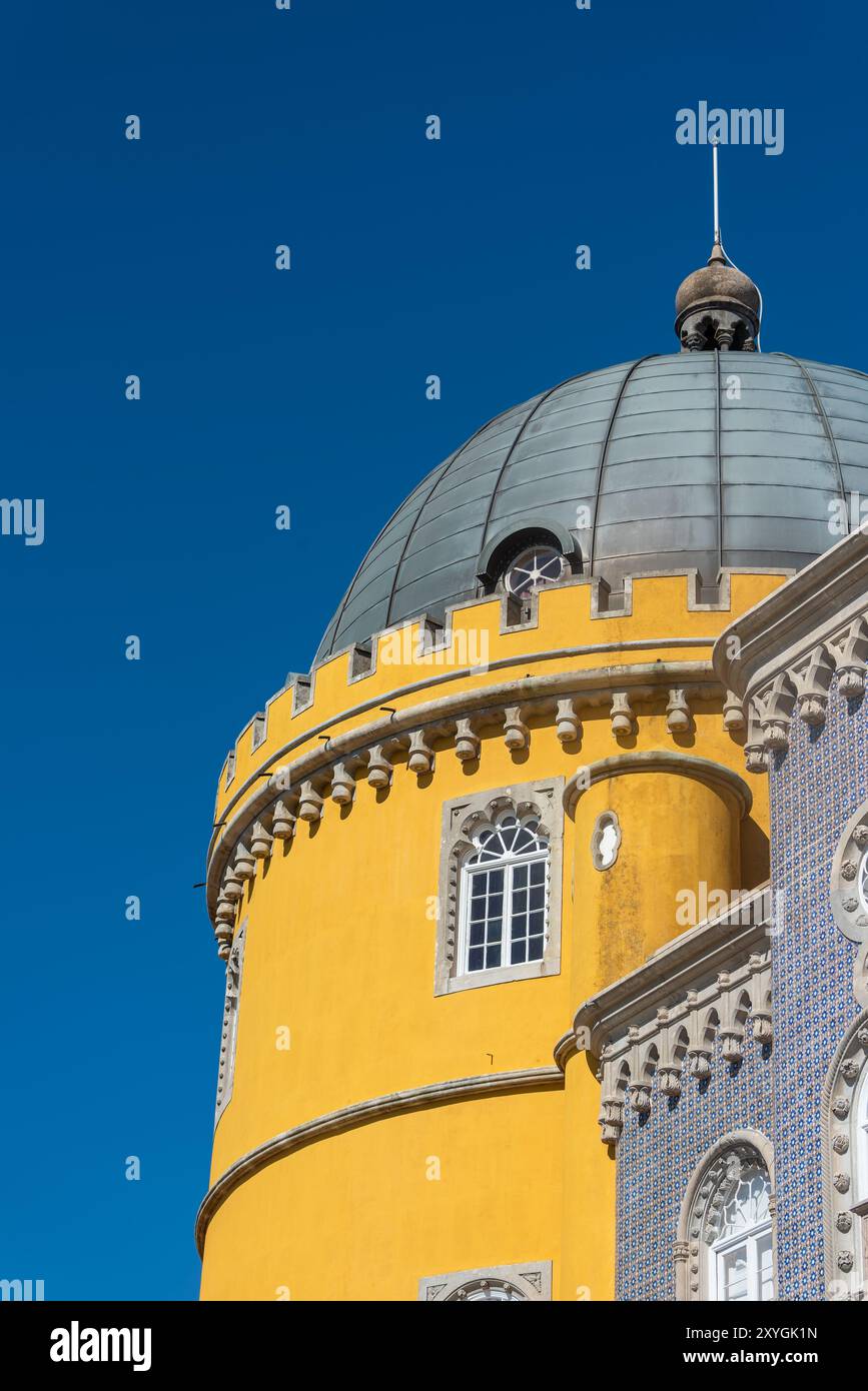 Pena Palace Architecture Sintra Portugal // SINTRA, Portugal — The vibrant and eclectic exterior architecture of Pena Palace, showcasing its blend of Romanticist, Moorish, and Neo-Manueline styles. The palace's colorful facades, ornate details, and whimsical elements epitomize 19th-century Romantic architecture and King Ferdinand II's vision of a fairytale castle. Stock Photo