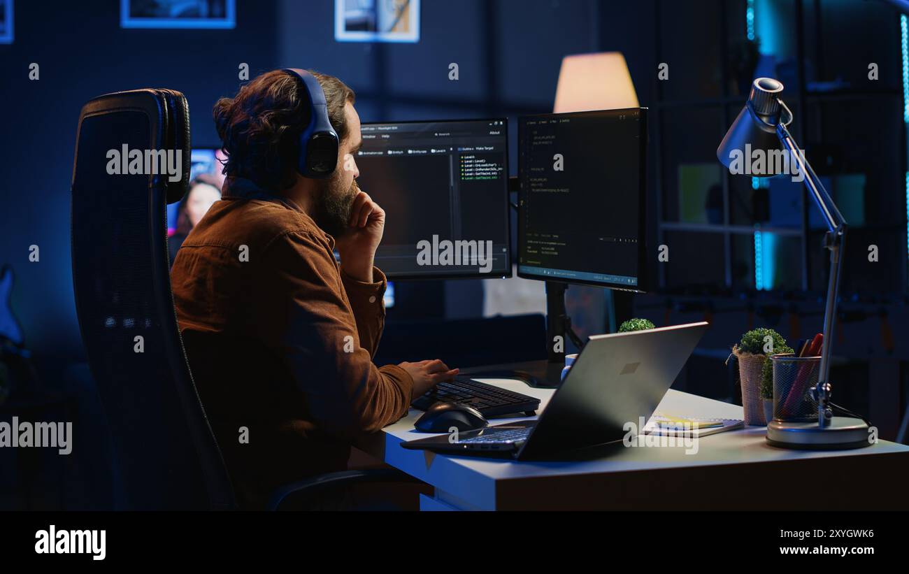 Hyperactive software developer suffering from adhd affliction, writing code, drinking coffee, listening music, arranging desk objects. Distracted IT admin doing multitasking in home office, camera A Stock Photo