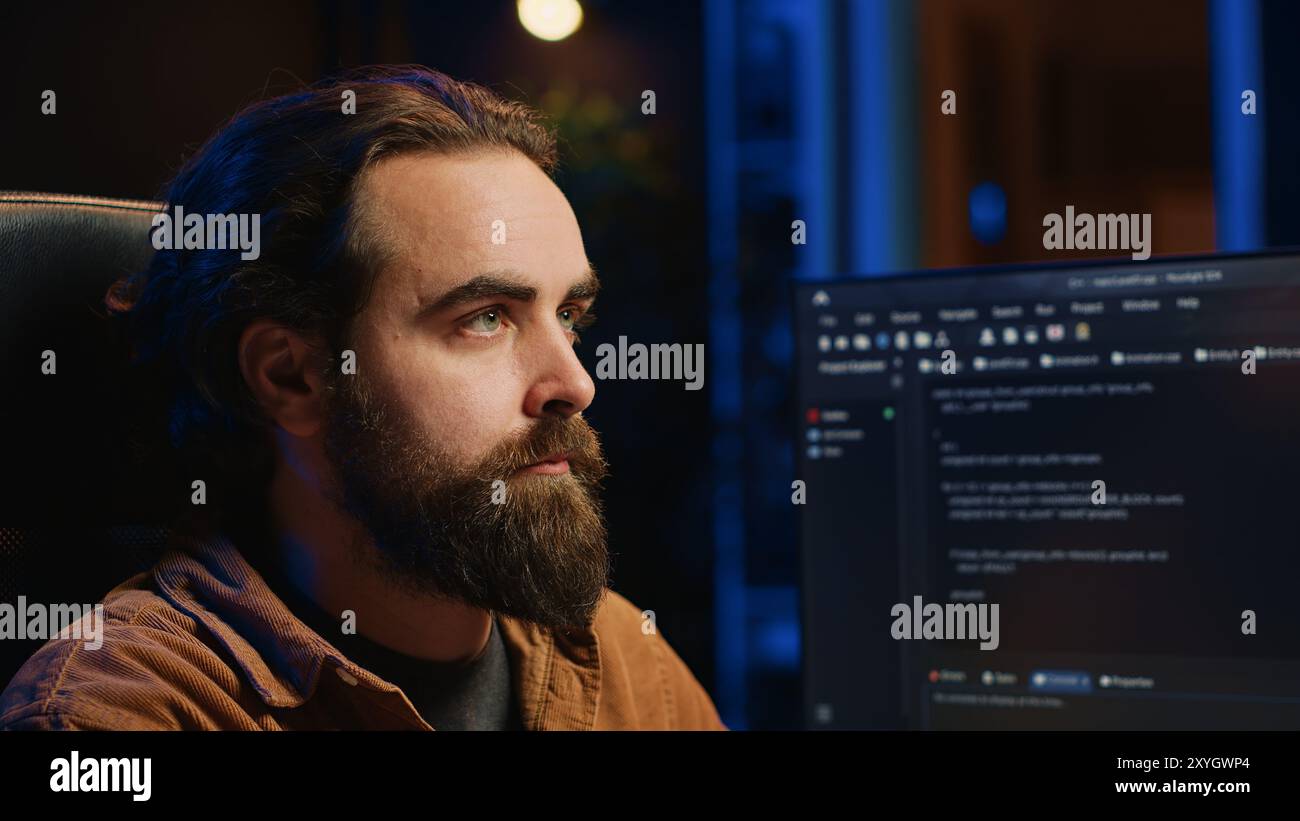Developer overthinking solutions while doing programming during remote job shift in office while drinking coffee. IT admin enjoying hot beverage working on PC early in the morning, camera A close up Stock Photo