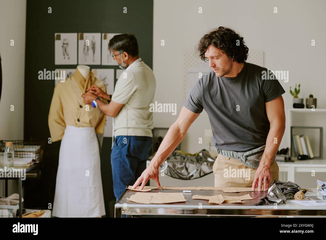 Biracial atelier workers working on new female collection together in modern atelier Stock Photo