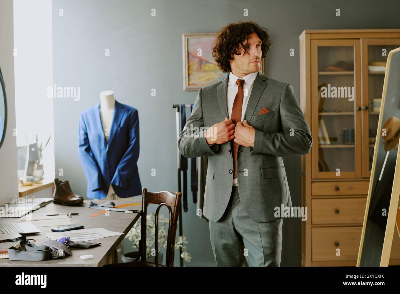 Brutal male model adjusting jacket while looking in mirror Stock Photo
