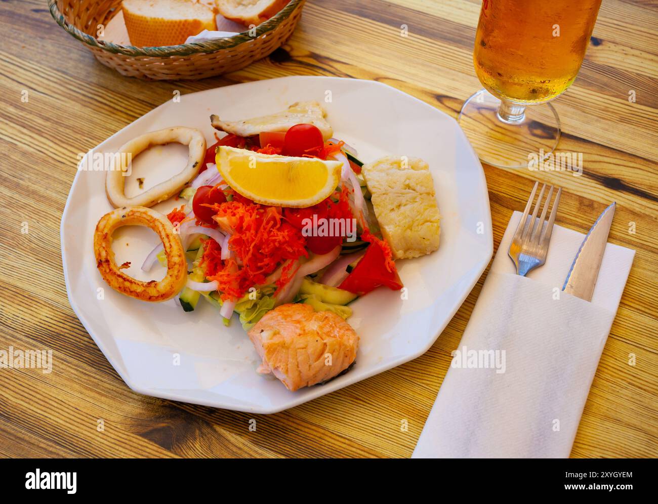 Grilled fish and squid rings with vegetable salad Stock Photo - Alamy