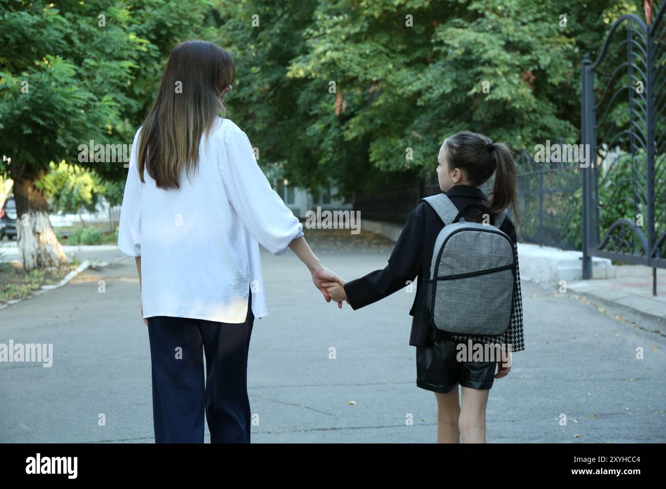 Mother and daughter holding hands outdoors, back view Stock Photo - Alamy