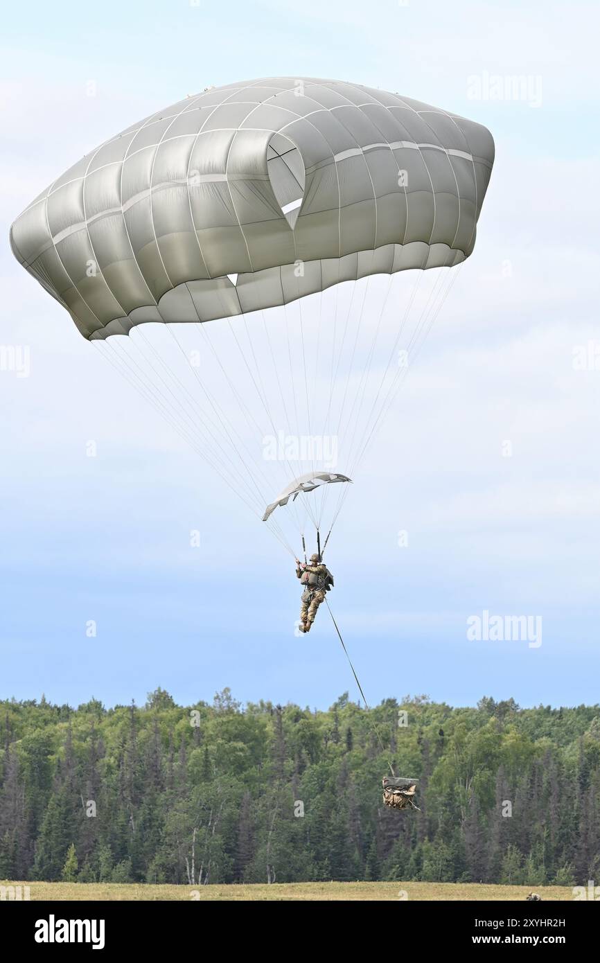 A Spartan paratrooper from the 2nd Infantry Brigade Combat Team (Airborne), 11th Airborne Division prepares to land on Malemute Drop Zone at Joint Base Elmendorf-Richardson as part of the celebration of National Airborne Day, Friday, Aug. 16. This year, nearly 84 years after the first official Army parachute jump at what was then Fort Benning (now Fort Moore), Georgia, in 1940, the U.S. Senate again passed a resolution designating August 16, 2024, as “National Airborne Day,” commemorating the anniversary of that first jump. (Army photo/John Pennell) Stock Photo