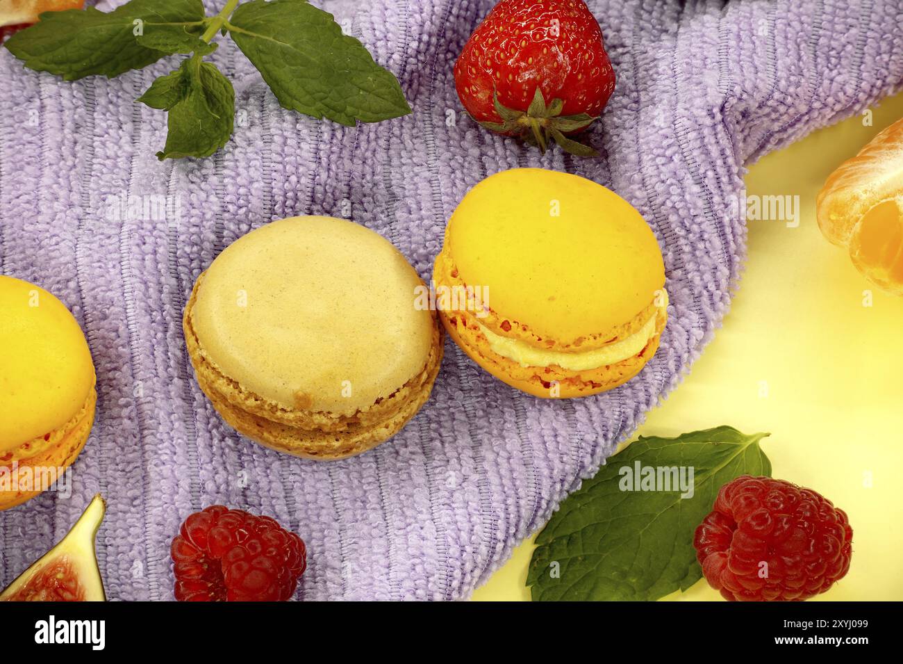 Table filled with array of macaroons and fruits visual appeal of the food, highlighting the freshness of the fruits and the indulgent appeal of the ma Stock Photo