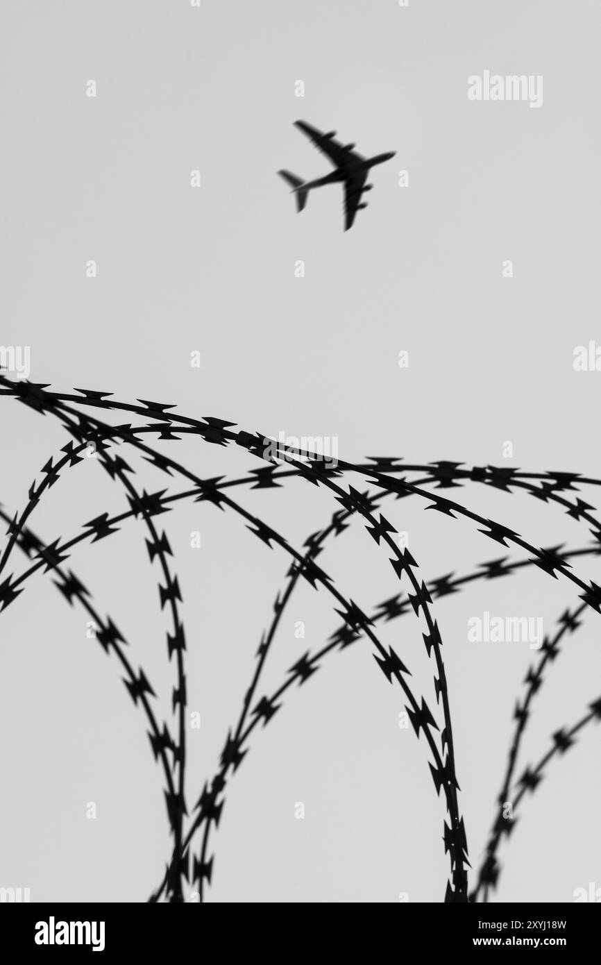 Symbolic image, deportation flights of illegal and delinquent migrants, passenger aircraft, airport, security fence, barbed wire, black and white imag Stock Photo