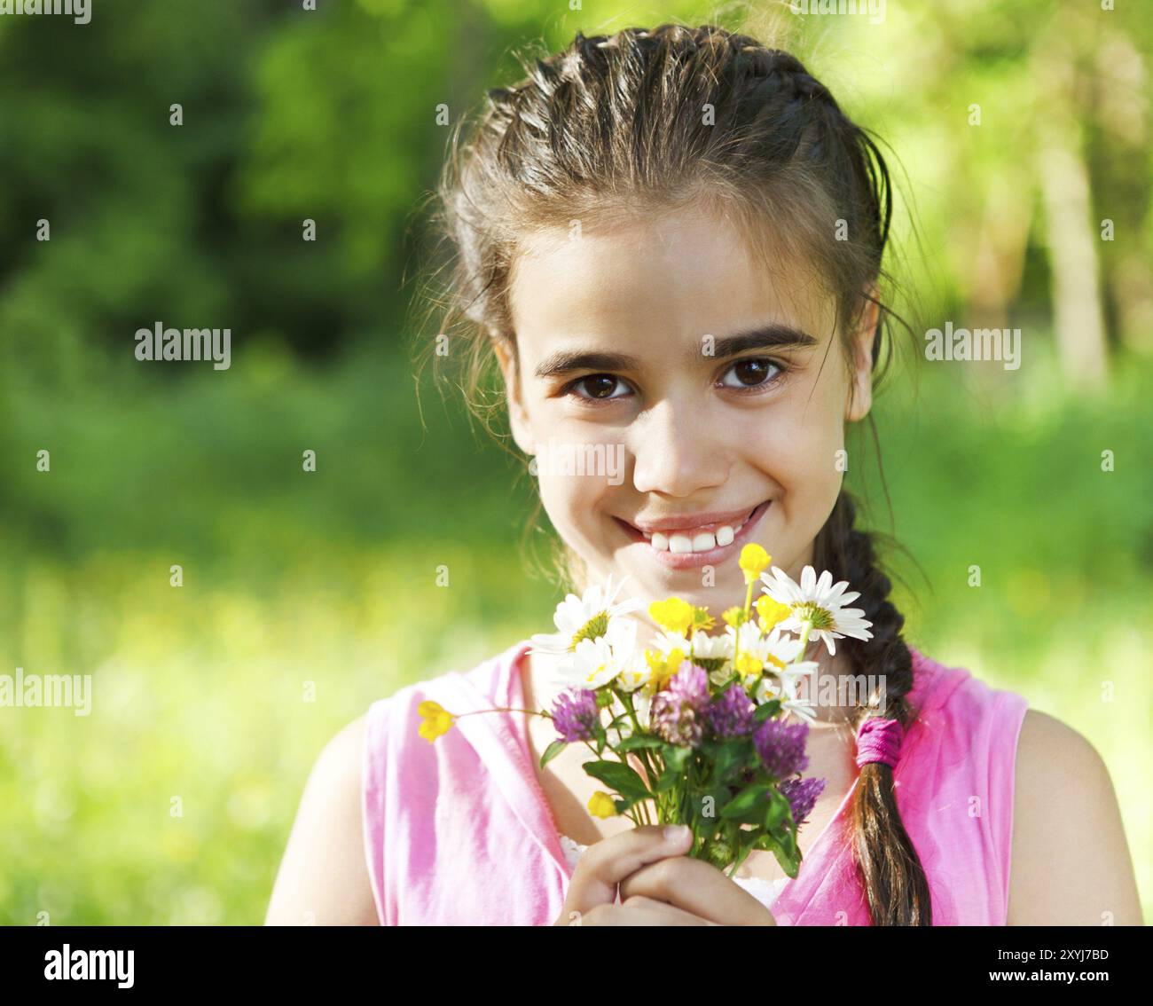 Close up portrait of little smiling girl with spring flowers bouquet ...