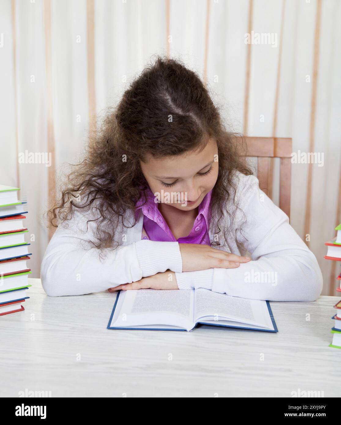 Little brunette reading girl with piles of books Stock Photo - Alamy