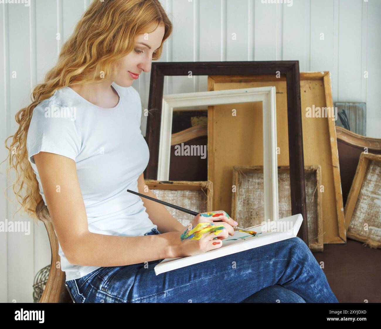 Portrait of female artist holding paintbrush in her studio Stock Photo