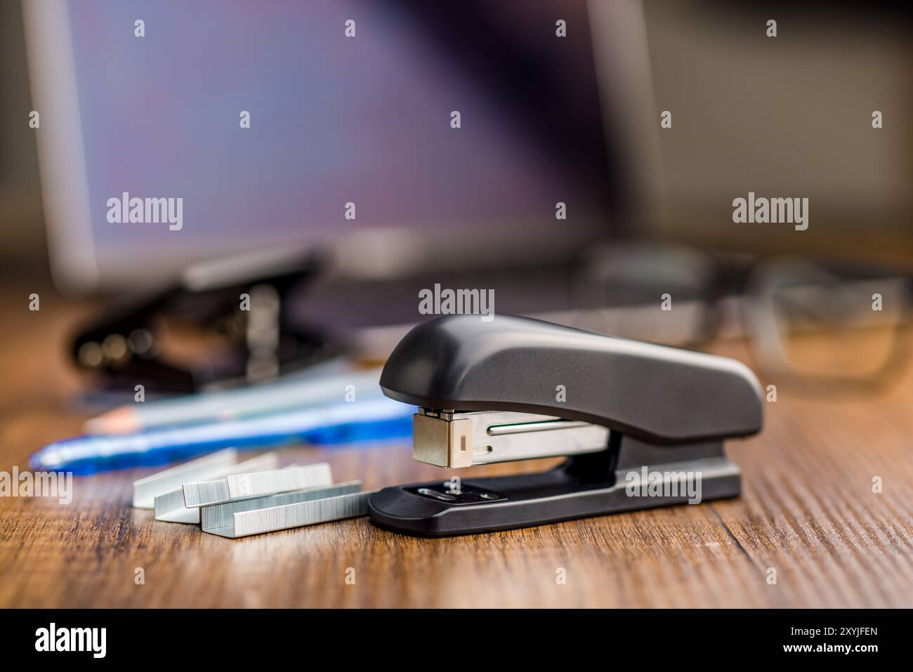 Black office stapler on a wooden table. Stock Photo