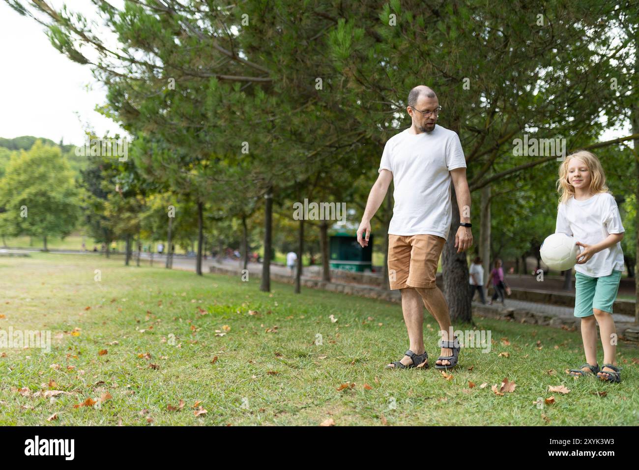 Father and daughter walking in park with volleyball Stock Photo - Alamy