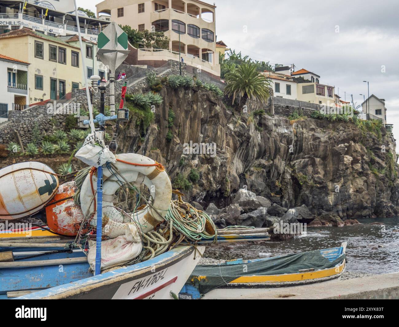 Houses and rocks in the background of a harbour with boats and fishing ...