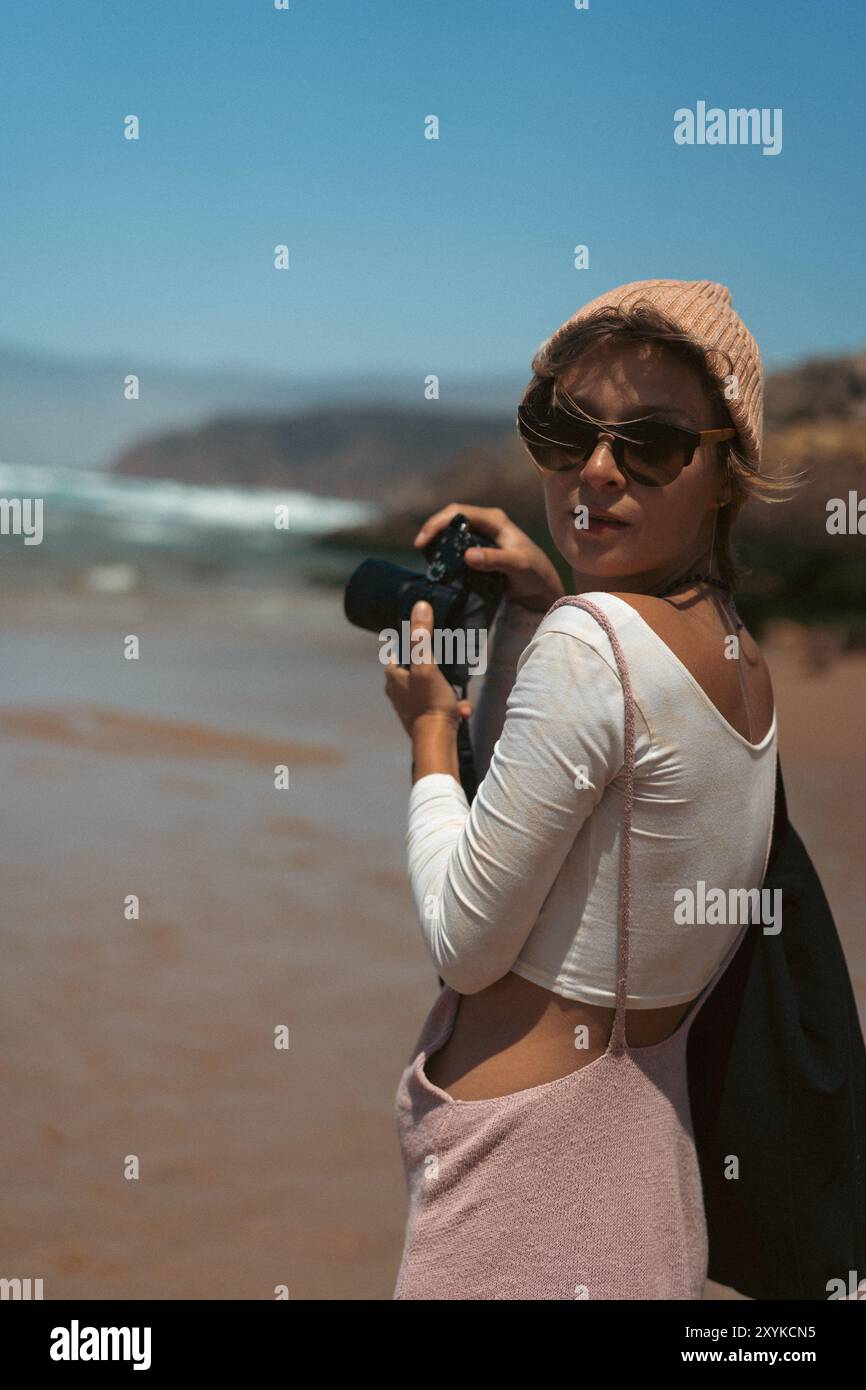 Woman photographing holding a camera on the beach on a windy day Stock ...