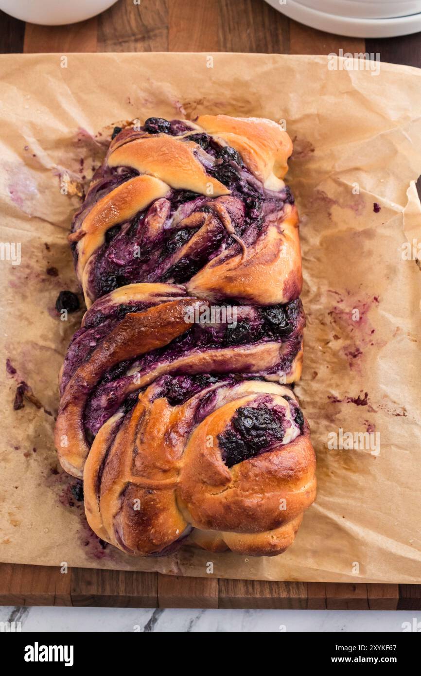 Whole blueberry cream cheese babka on parchment paper, freshly baked Stock Photo