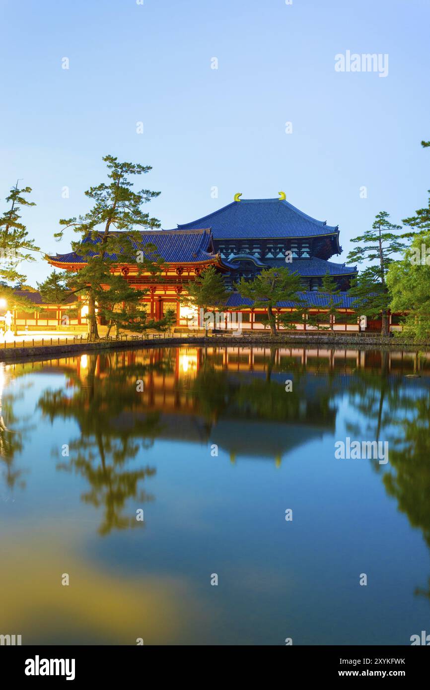 Haunting long exposure of front entry gate and Daibutsuden Great Buddha Hall reflected in a still pond at night in Todai-ji temple in Nara, Japan, Asi Stock Photo