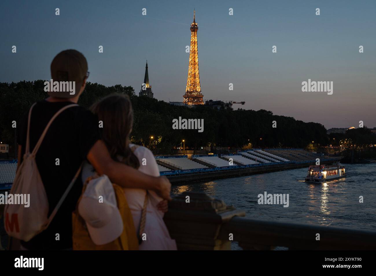 A couple watches the Eiffel Tower from a bridge during the 2024 Olympic Games, on Friday, August 2, 2024, in Paris, France. Stock Photo