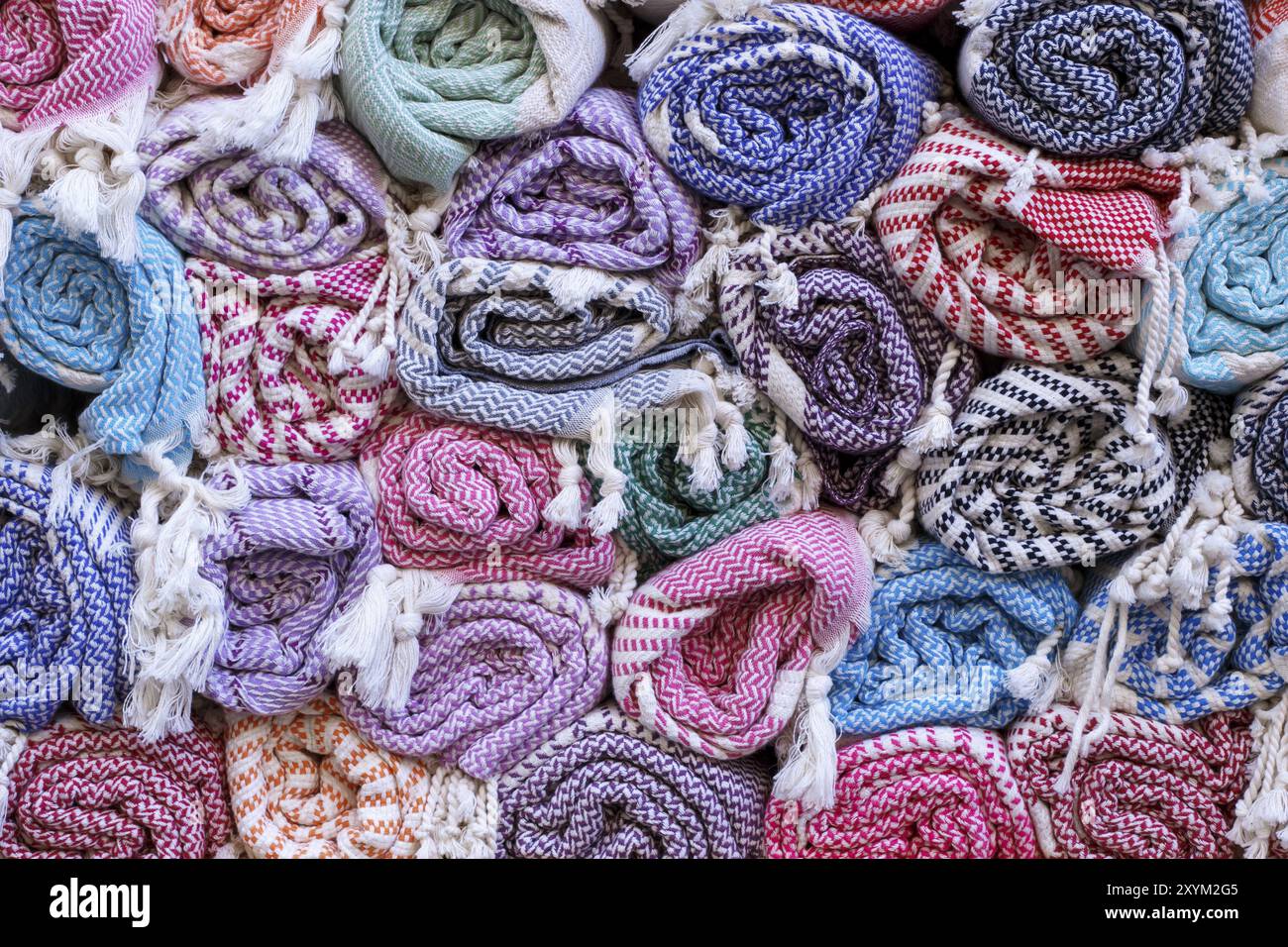 Colorful blankets, rolled up in a roll on the old market, traditional textiles Stock Photo