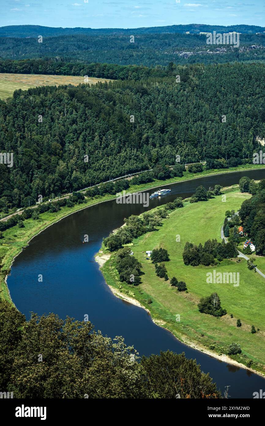 Aerial view of tourist ship cruising on winding river through forested ...
