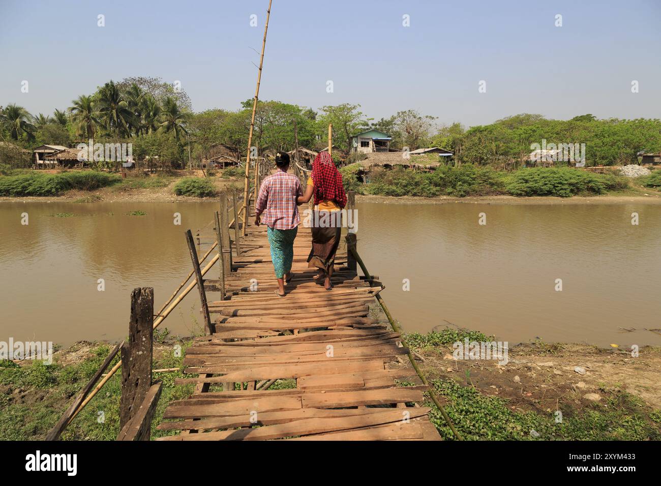 Two woman on a wooden bridge in Myanmar Stock Photo - Alamy