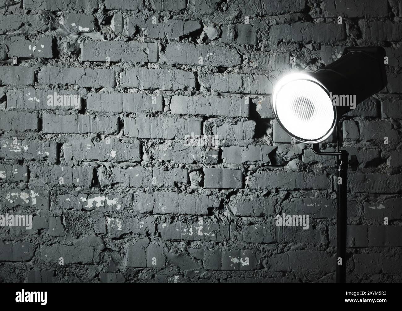 Studio flash near the gray damaged brick wall Stock Photo - Alamy