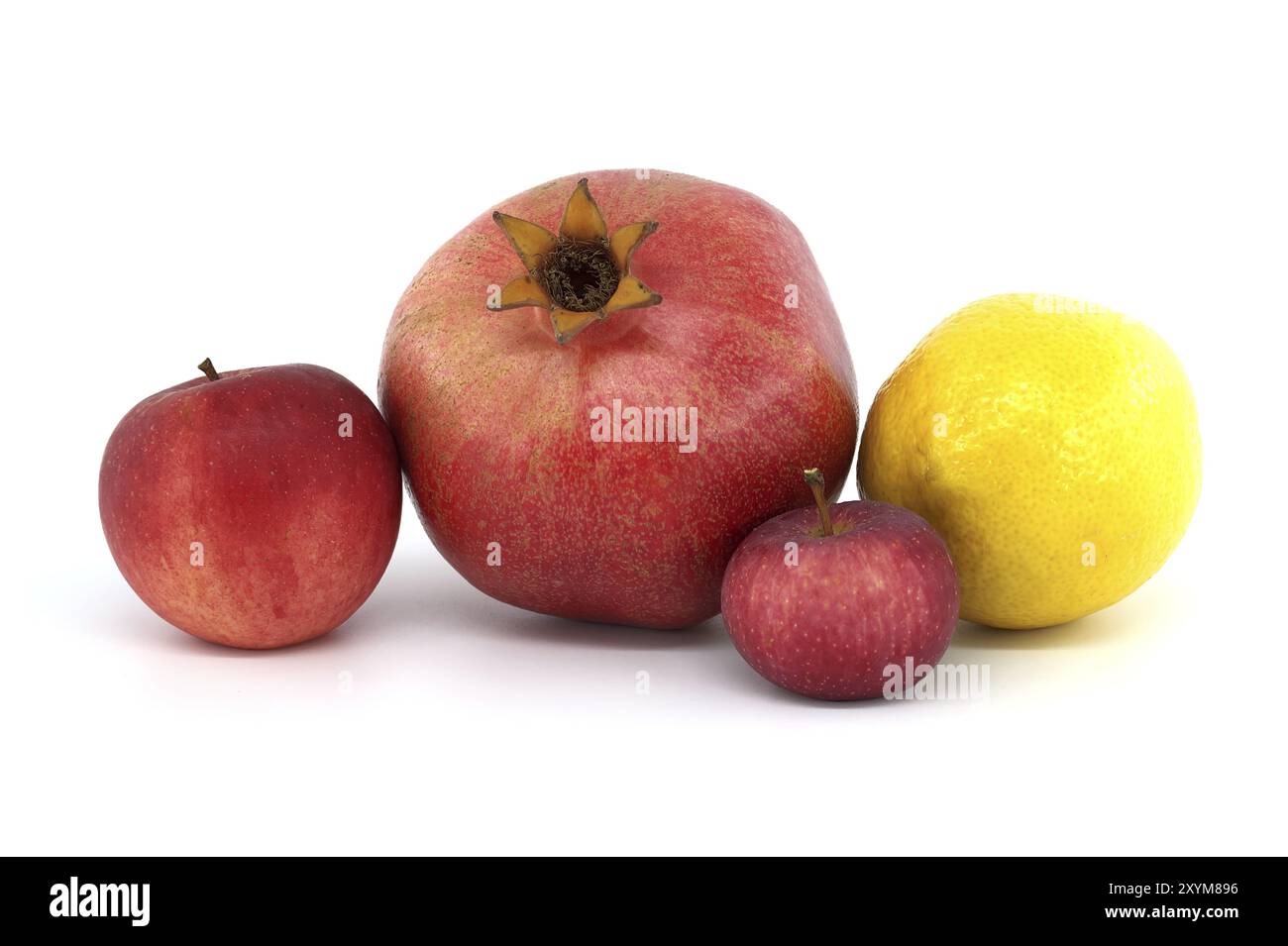 Fresh ripe pomegranate, red apples and whole yellow lemon isolated on white background Stock Photo