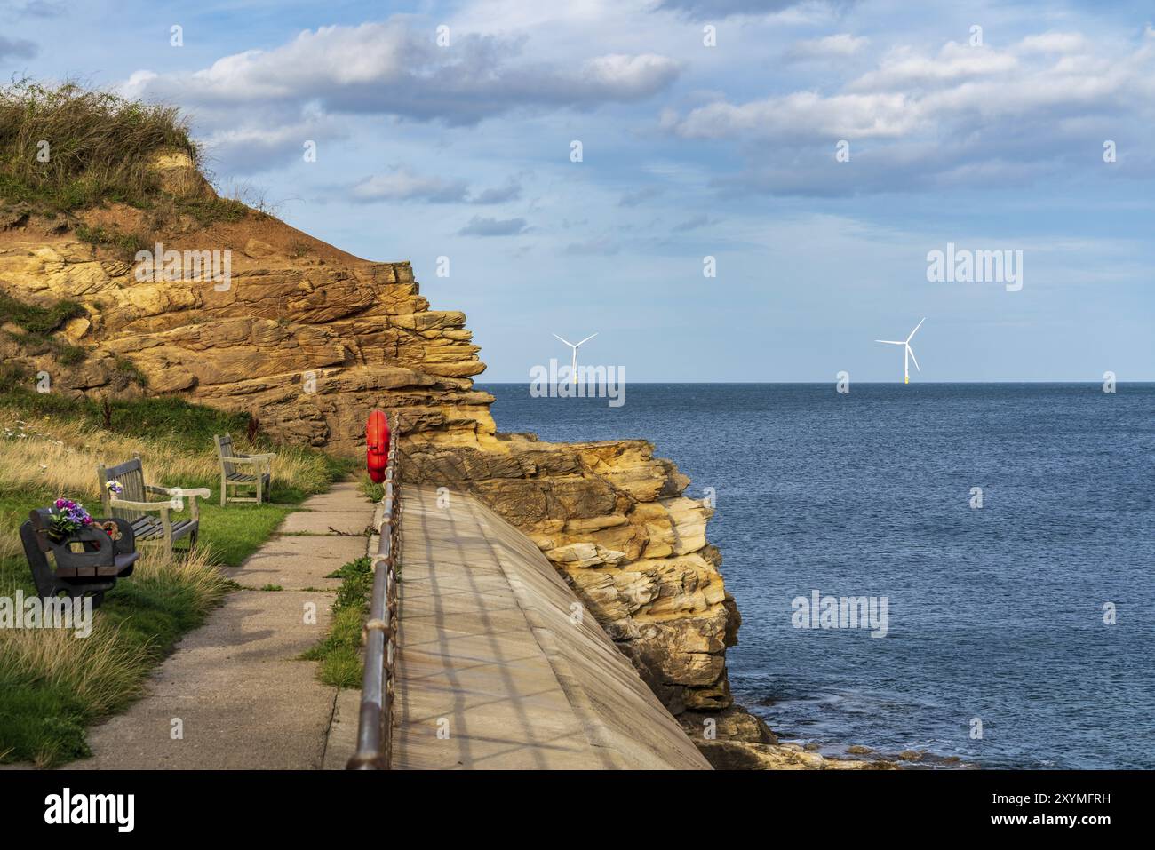 North Sea coast in Collywell Bay, Seaton Sluice in Northumberland, England, UK, with wind turbines in the background Stock Photo