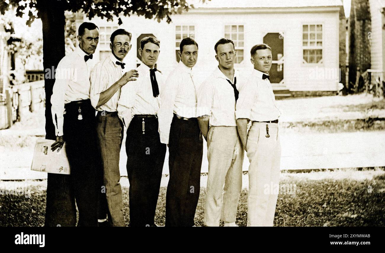 A lineup of six men in white shirts outdoors, possibly office worker colleagues, circa 1904-1920. Stock Photo