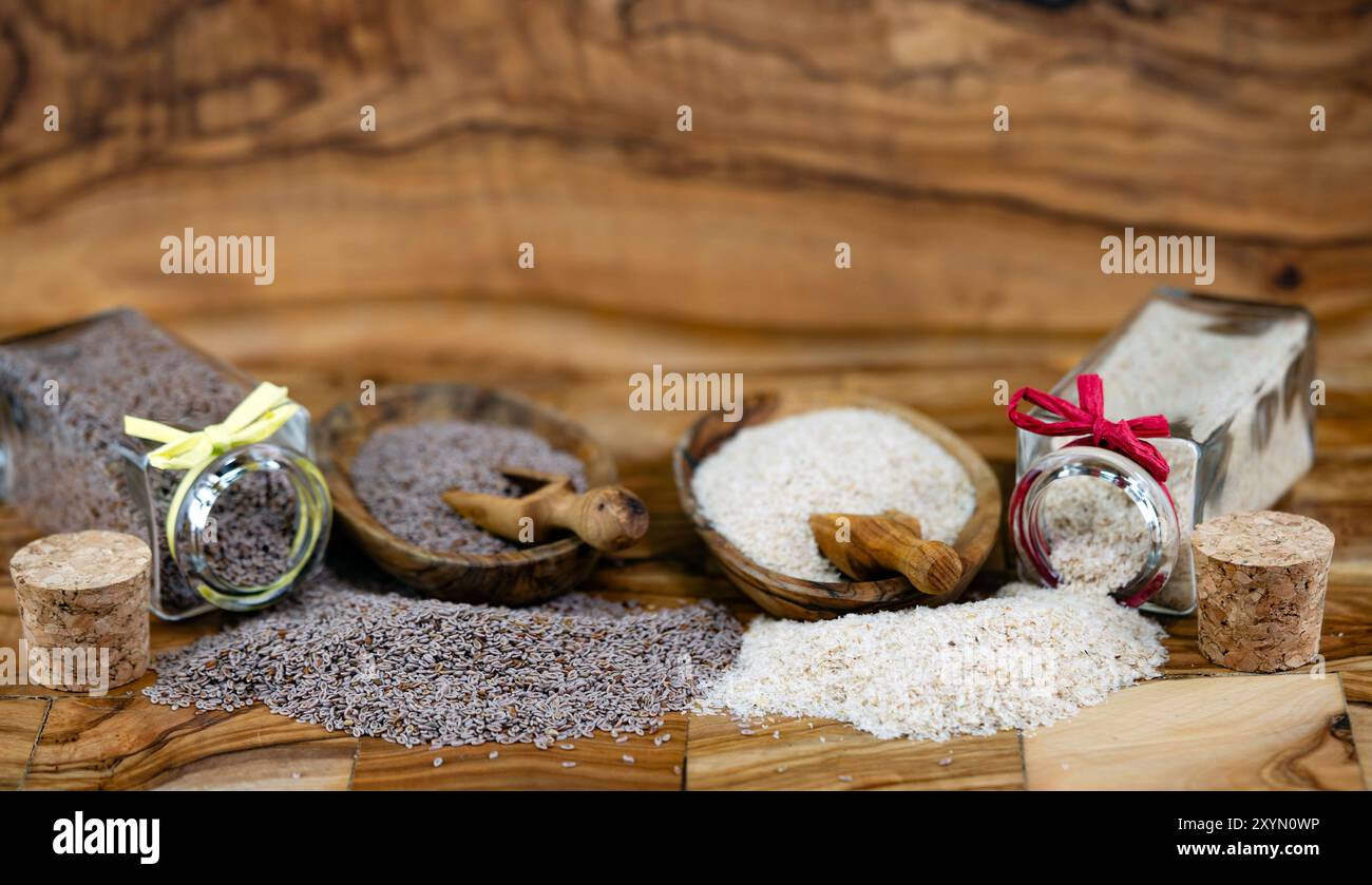 Blond plantain, Desert Indianwheat, Blond psyllium, Ispaghol (Psyllium ovata, Plantago ovata), Psyllium seeds and psyllium husks in jars and on wooden Stock Photo
