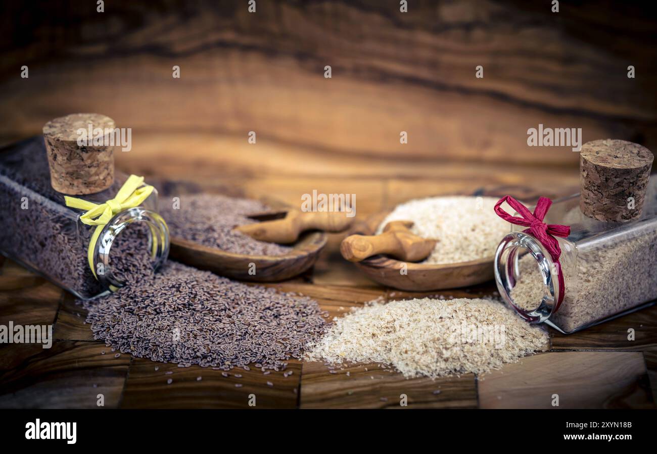 Blond plantain, Desert Indianwheat, Blond psyllium, Ispaghol (Psyllium ovata, Plantago ovata), Psyllium seeds and psyllium husks in jars and on wooden Stock Photo