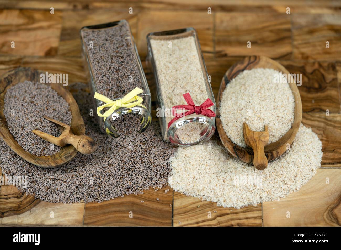 Blond plantain, Desert Indianwheat, Blond psyllium, Ispaghol (Psyllium ovata, Plantago ovata), Psyllium seeds and psyllium husks in jars and on wooden Stock Photo