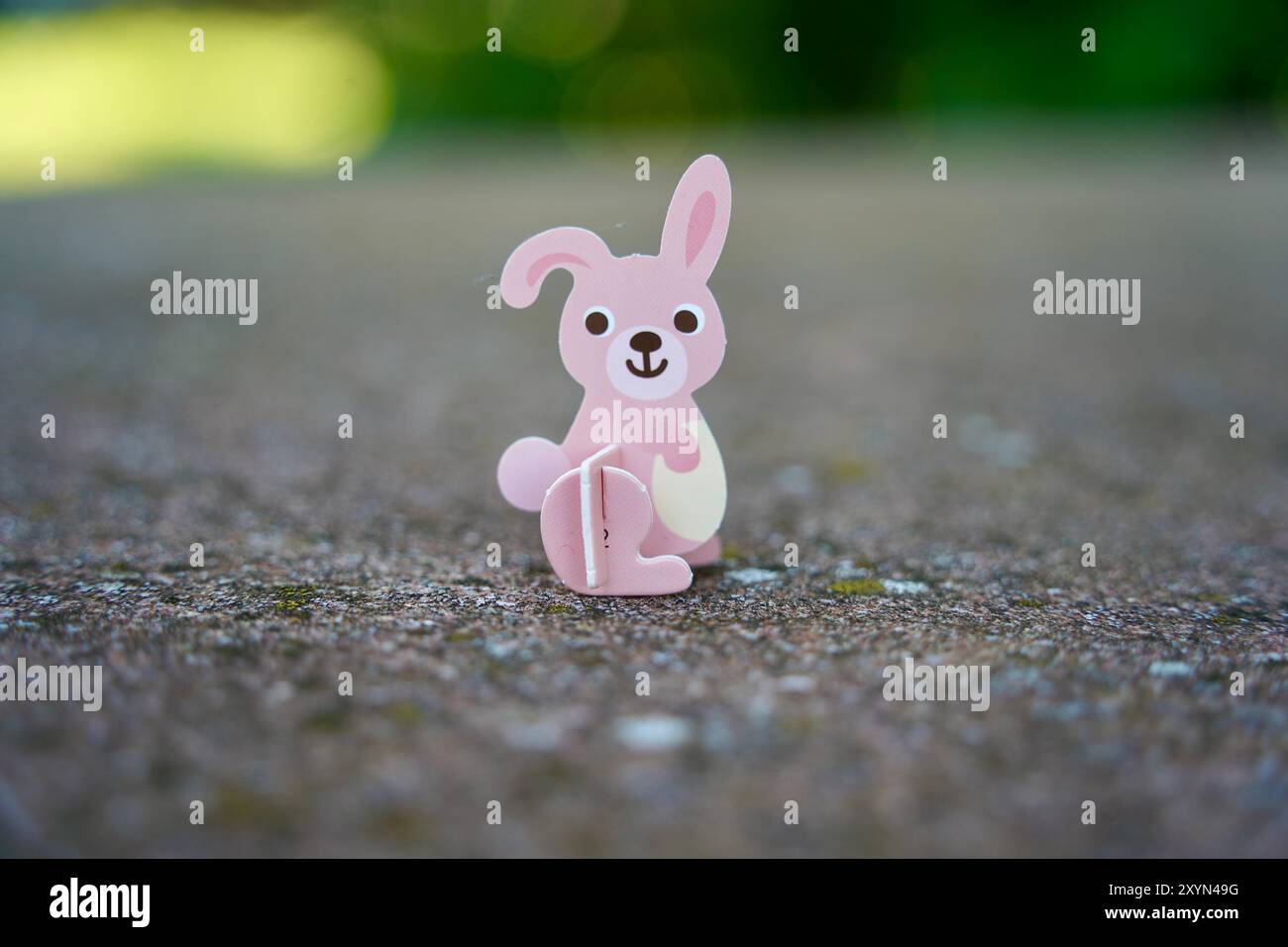 Small cute pink rabbit cardboard figure. Animal figurine toy. Stock Photo