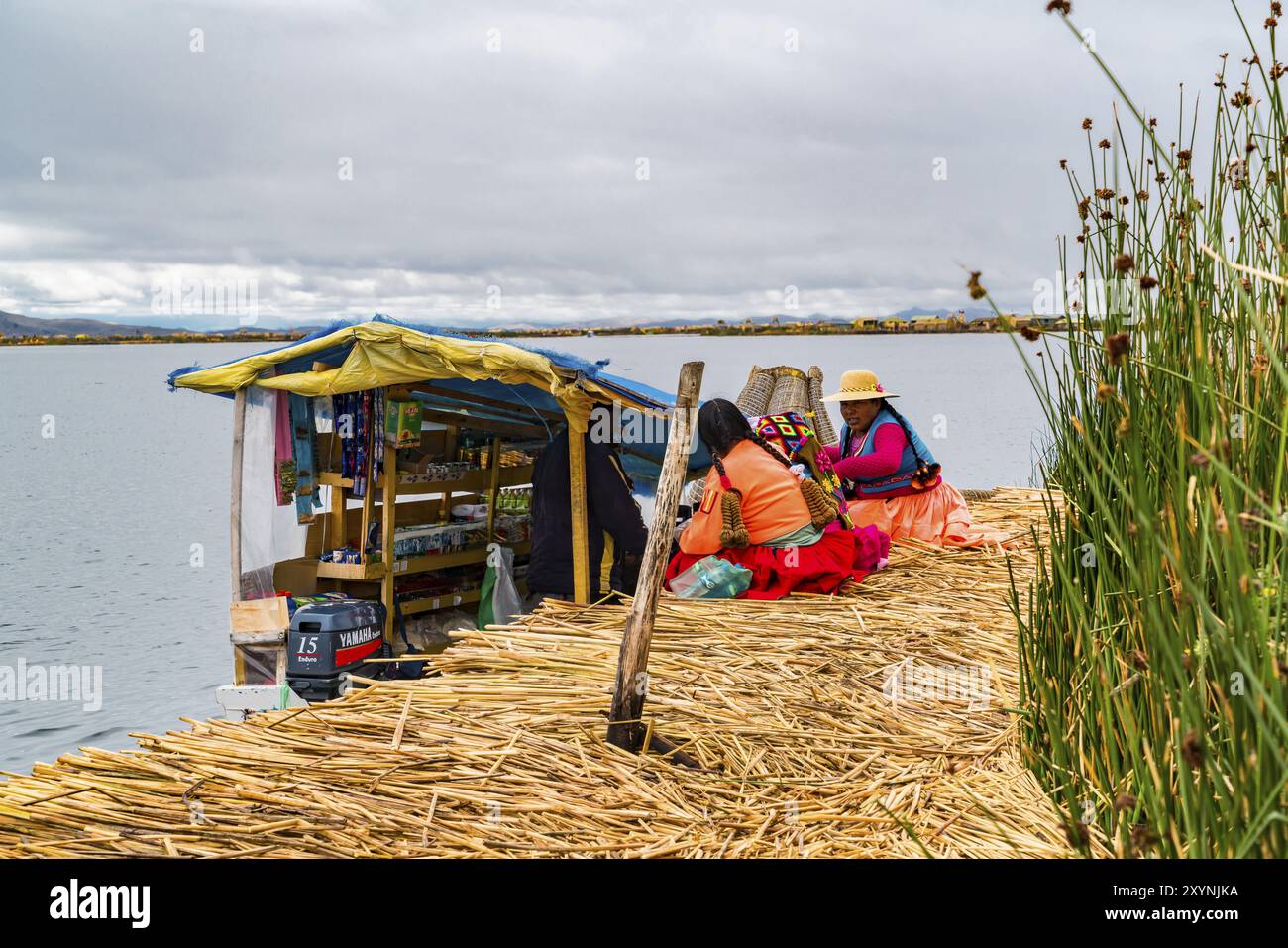 PUNO, PERU, FEBRUARY 1, 2016 : Uru woman wearing traditional cloths buying food and necessary things from a boat market at Uros Floating Island on Lak Stock Photo