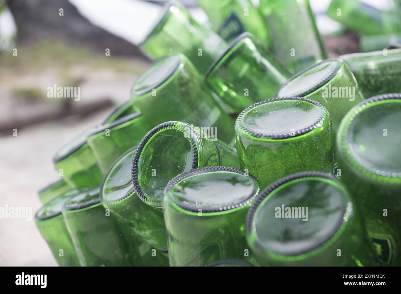 Beer Rings Polution Pile of empty green beer bottles thrown away on a beach illustrate ...