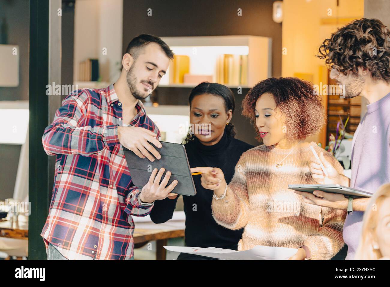 Four businesspeople having a productive meeting and using a digital tablet while working on a project in the office Stock Photo