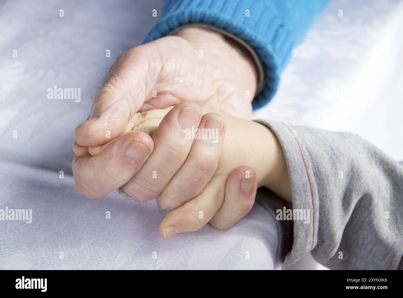 Senio holding the hand of a young child Stock Photo - Alamy