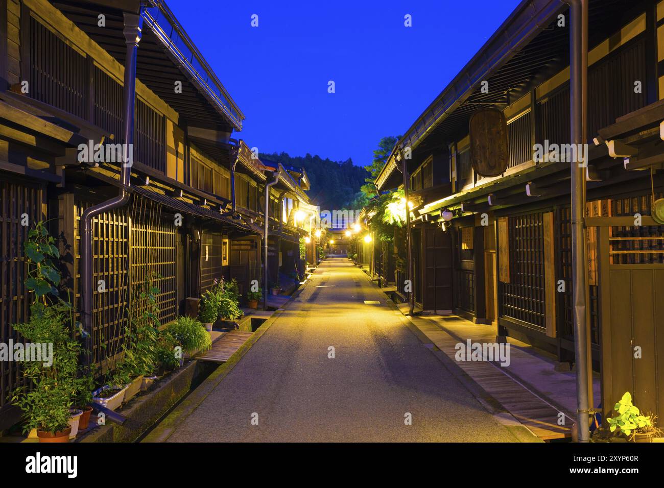 Takayama, Japan, July 10, 2015: Centered village street full of well preserved, traditional wooden homes at dusk in old town area of Hida-Takayama, Gi Stock Photo