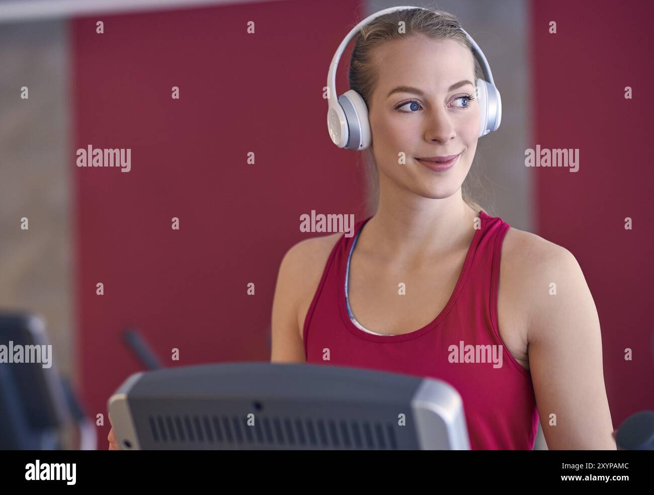 Smiling young blond woman wearing headphone in gym Stock Photo
