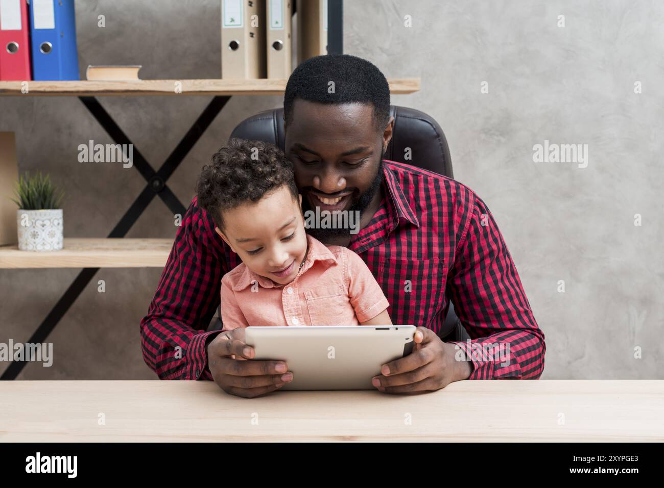 Black father son using tablet table Stock Photo