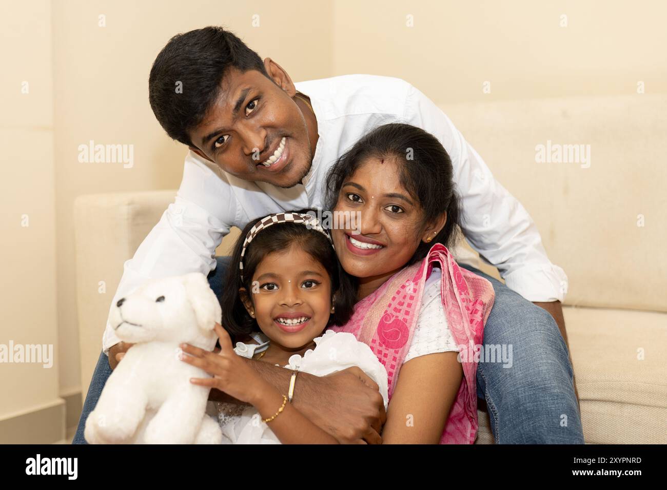 An indian couple and their child relax together on a couch Stock Photo ...