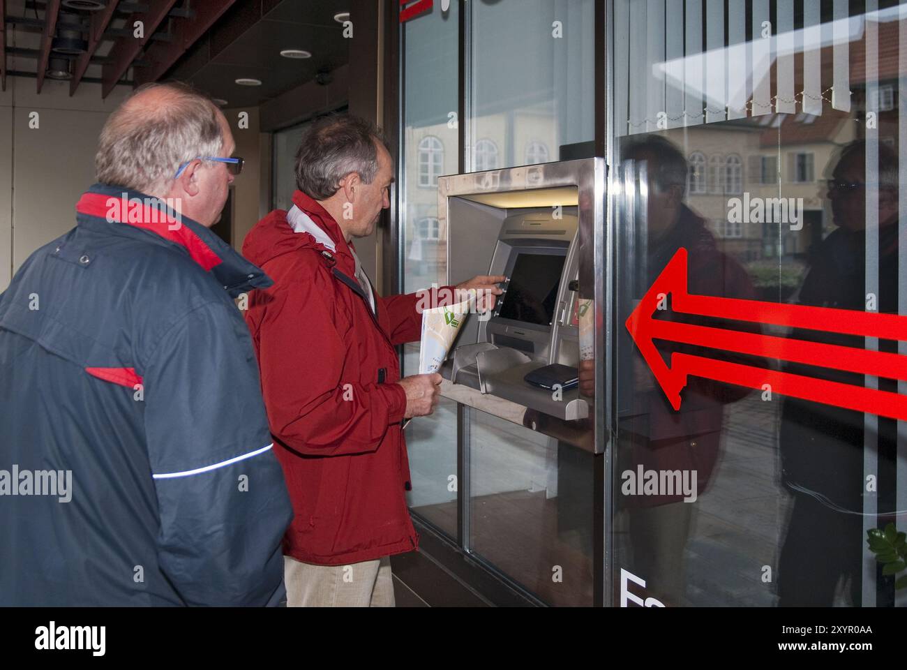 2 men standing at an ATM Stock Photo
