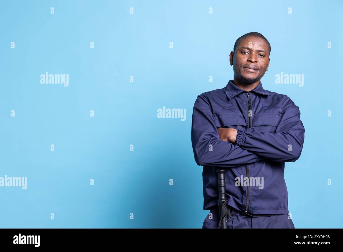 Portrait of proud security officer posing with arms crossed on camera ...